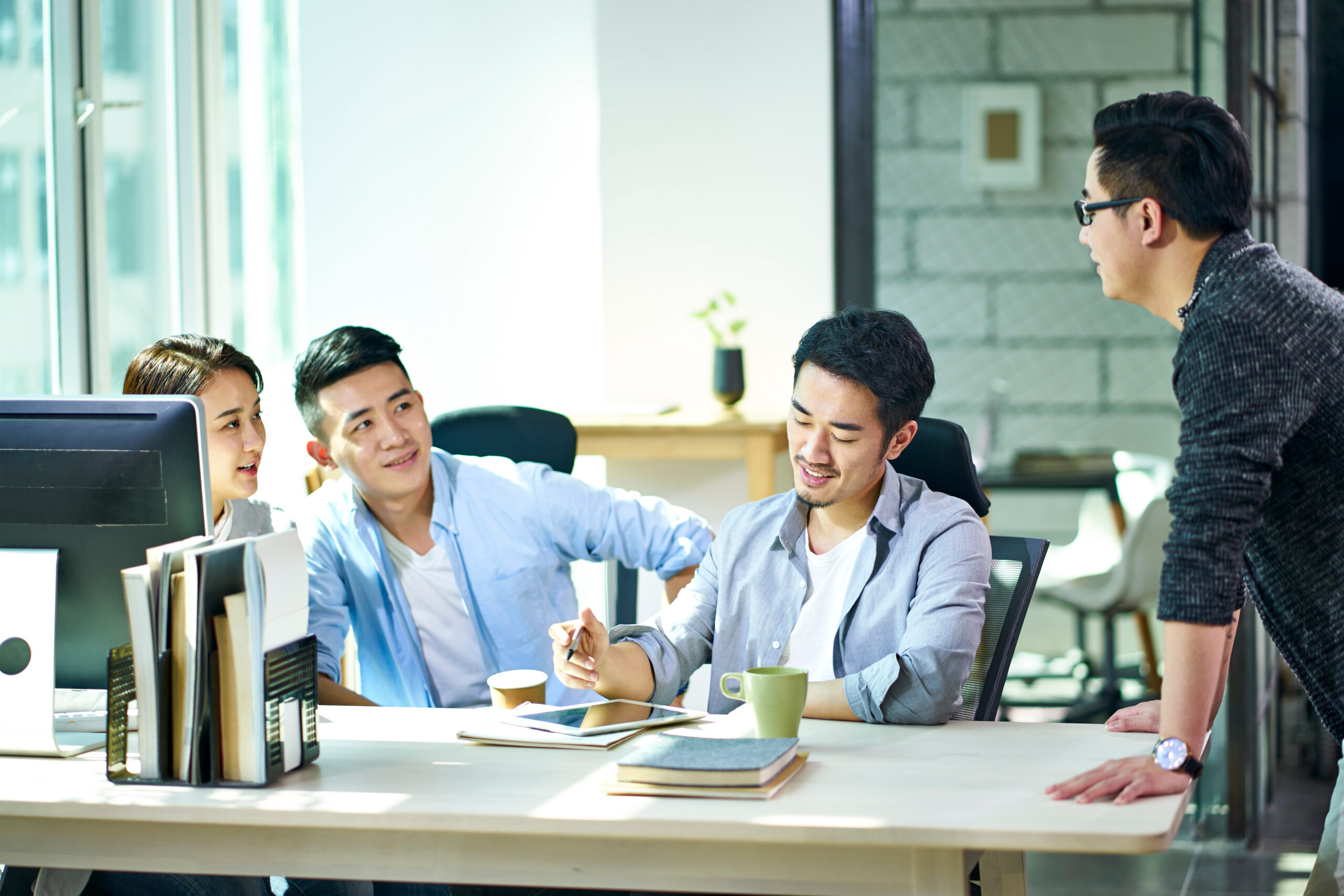 four young asian entrepreneurs meeting in office